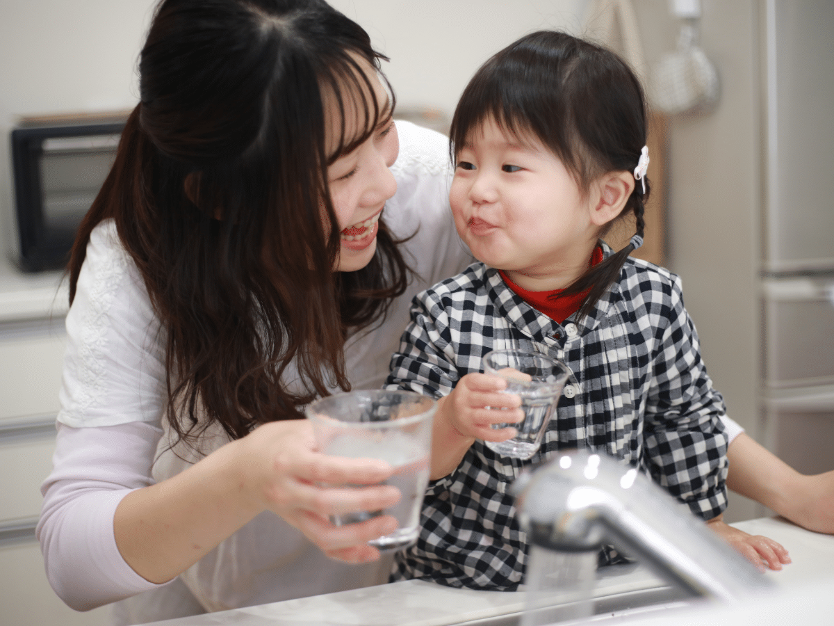 Family drinking filtered water from kitchen tap